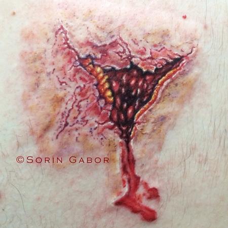 Sorin Gabor - realistic color bullet hole tattoo on back- exit wound